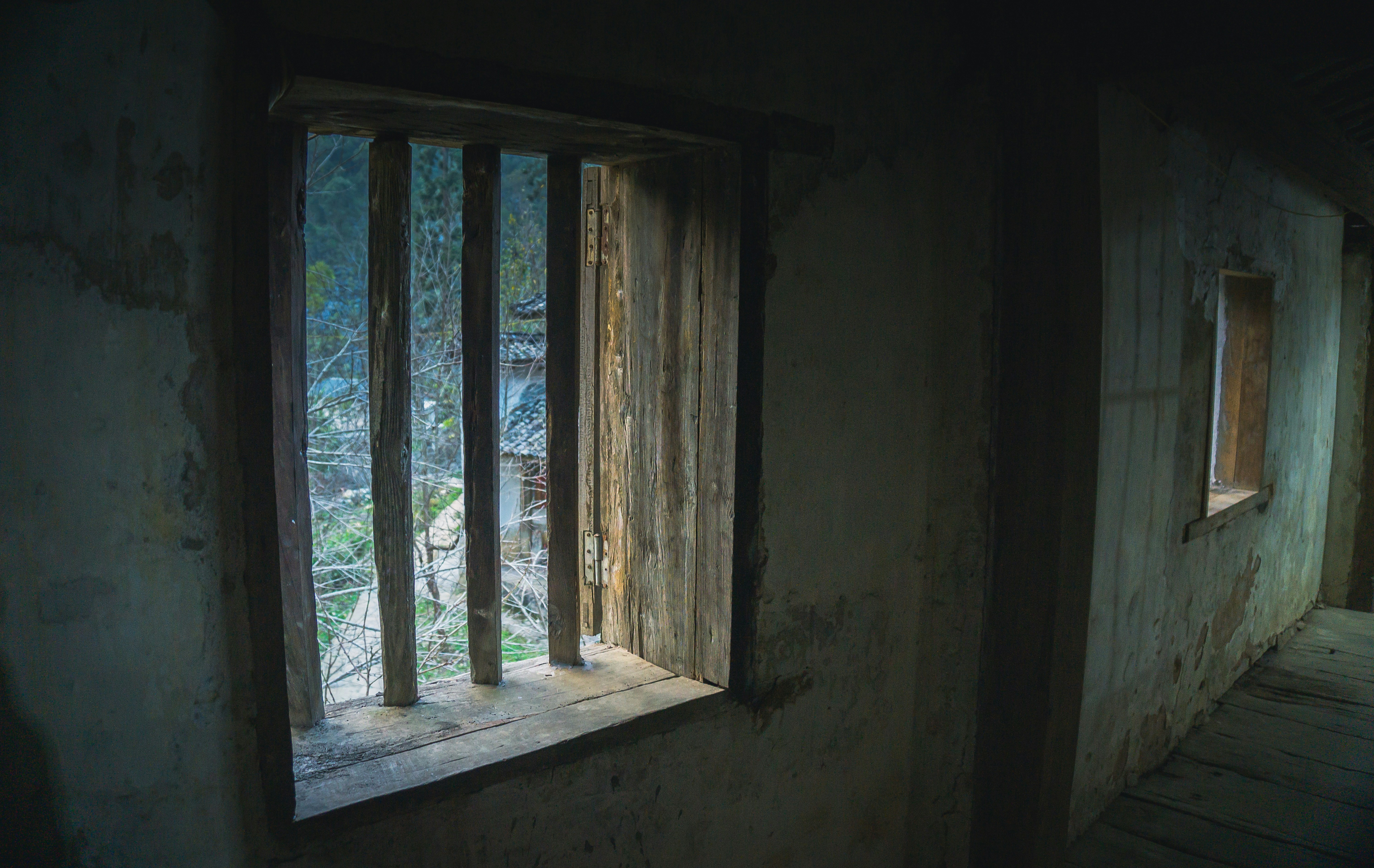 A dark room with a window and bars on it