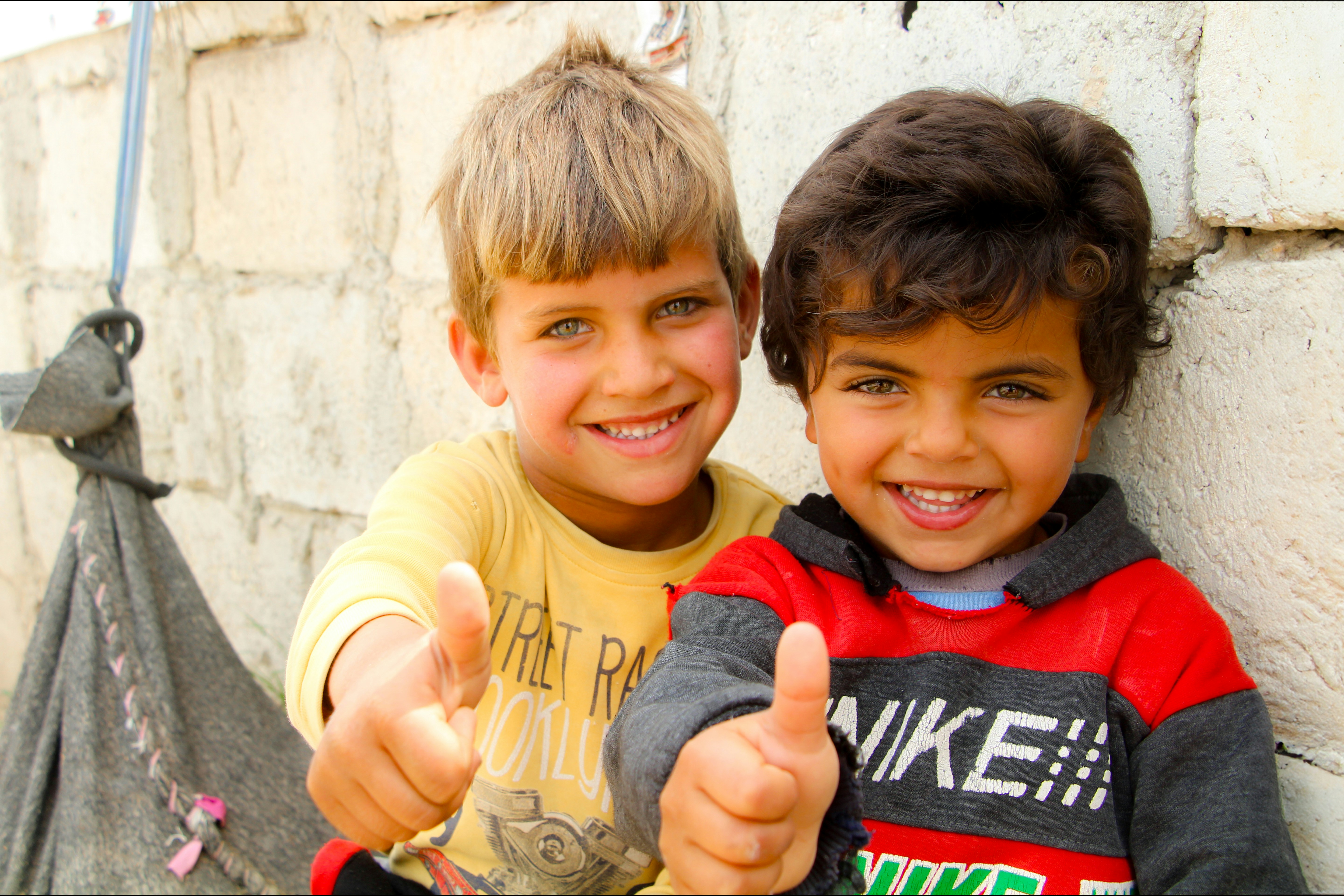 Two young boys giving the thumbs up sign, 