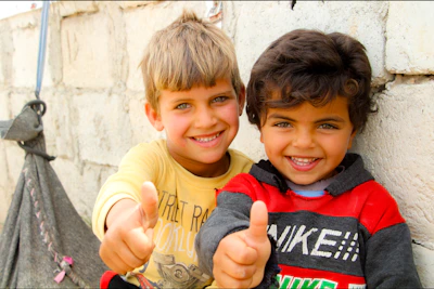 Two young boys giving the thumbs up sign