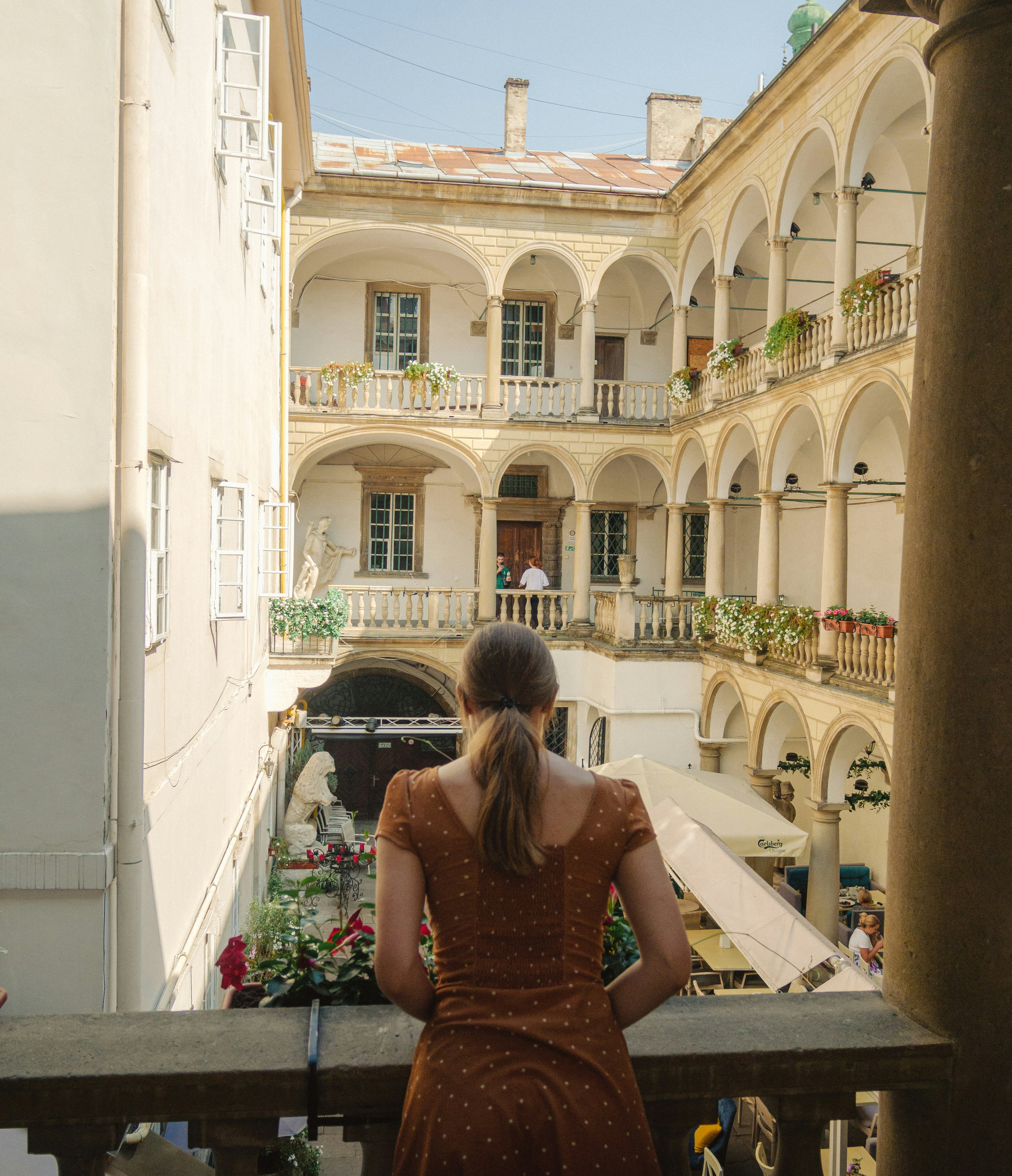 A woman standing on a balcony looking at a building