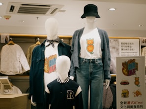 Two mannequins wearing shirts and hats in a store