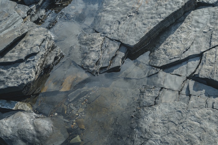 An aerial view of rocks and water in a stream