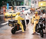 A couple of people on motor bikes on a city street