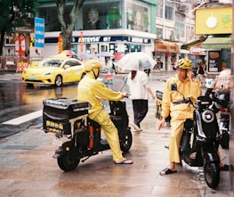 A couple of people on motor bikes on a city street
