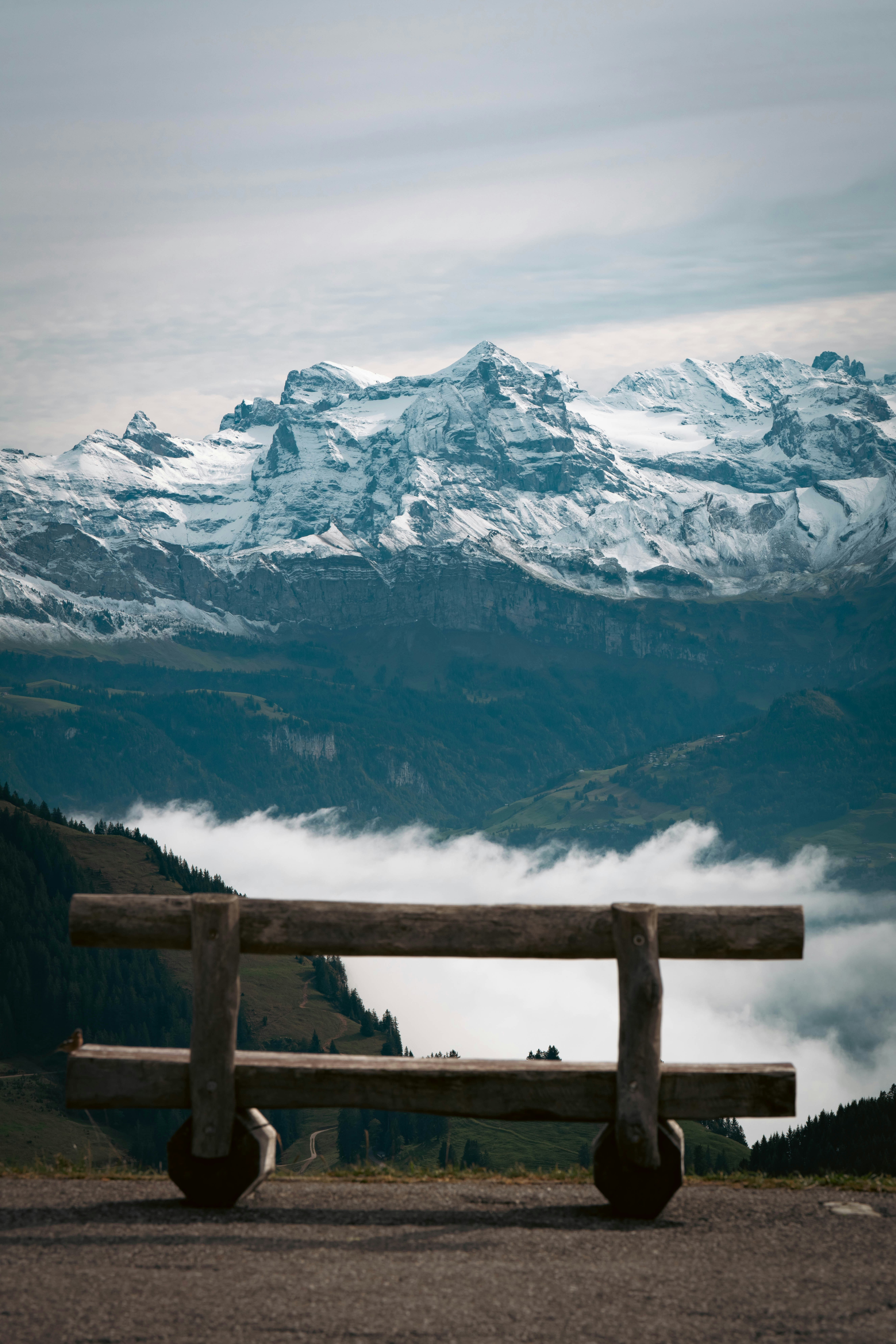 A wooden bench sitting on top of a mountain