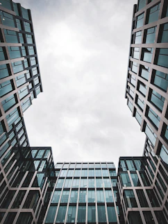 Looking up at two tall buildings in a city