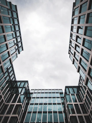 Looking up at two tall buildings in a city