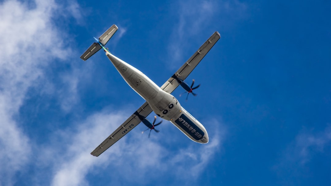 A small plane flying through a blue cloudy sky, US-Bangla Airlines ATR 72-600
