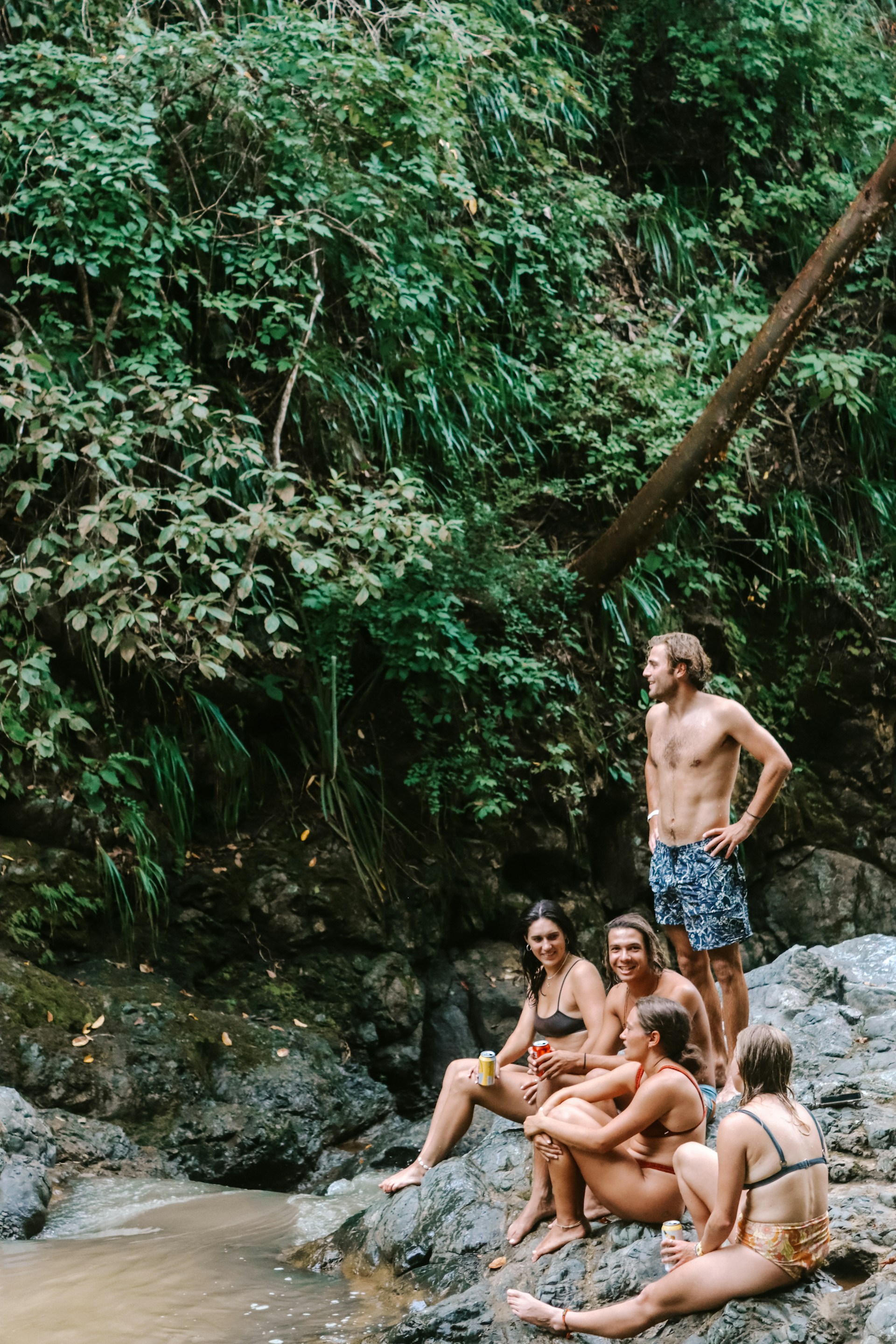 A group of people sitting on rocks in the water