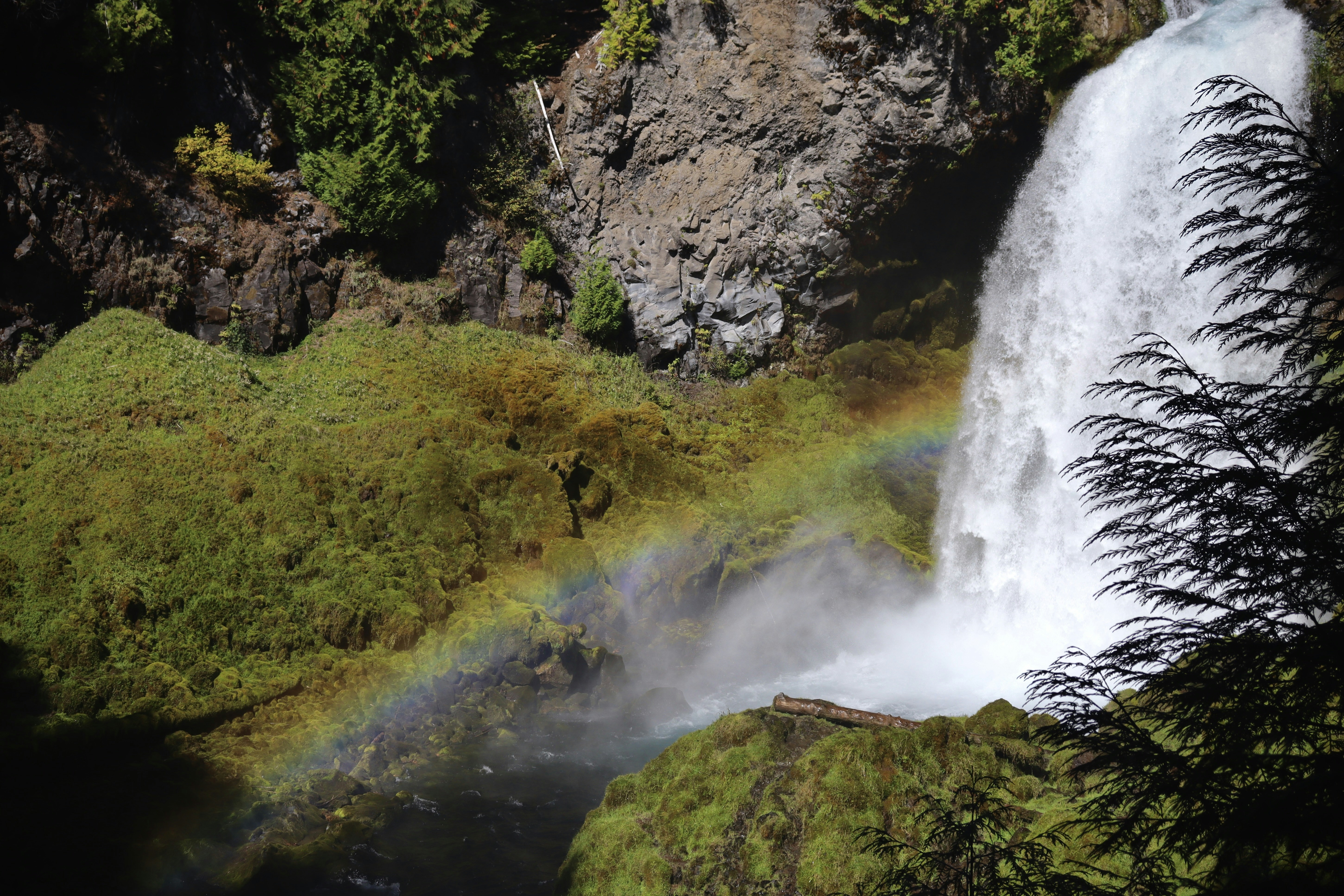 Una cascada con un arco iris en el centro