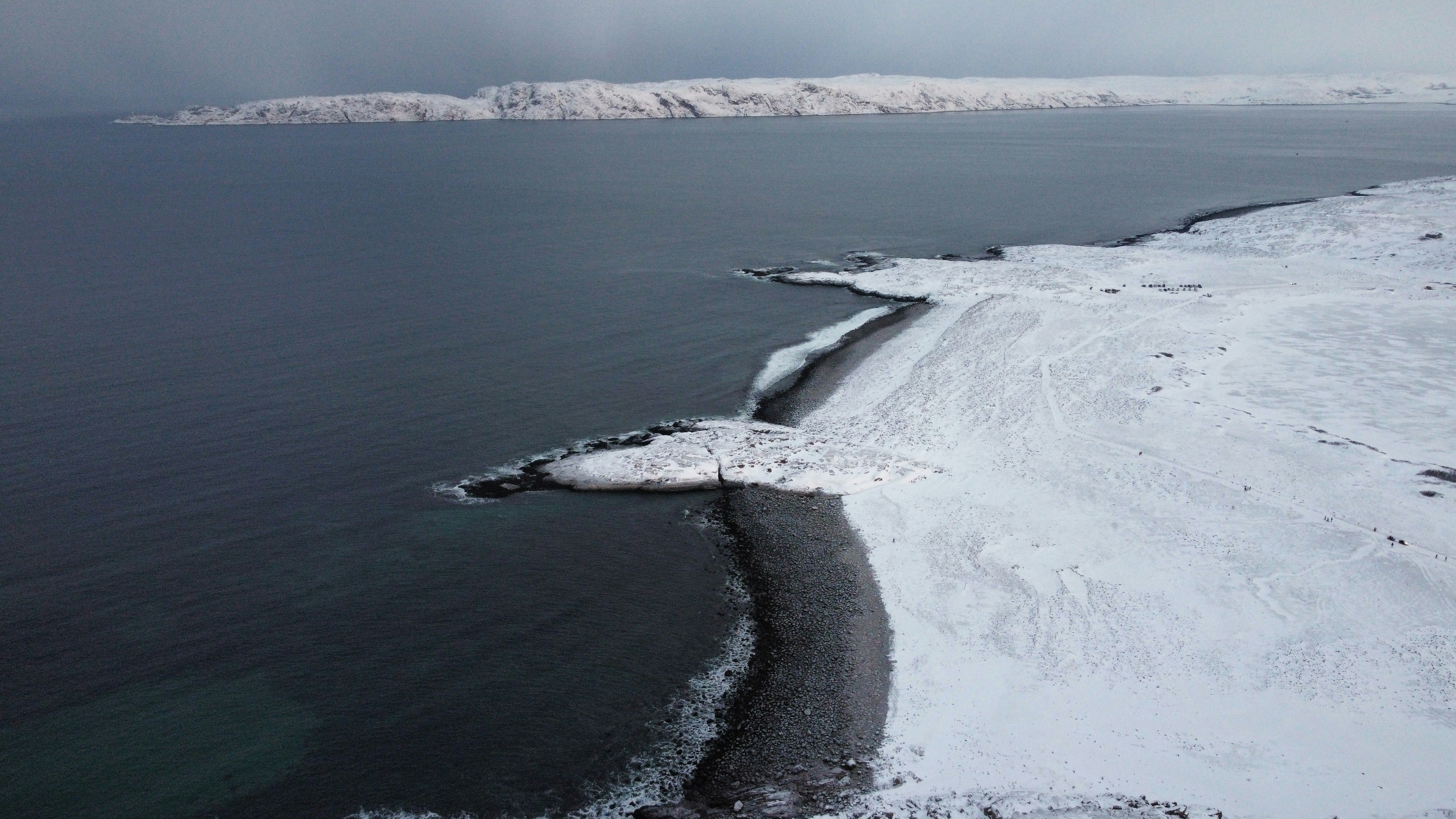 A large body of water surrounded by snow