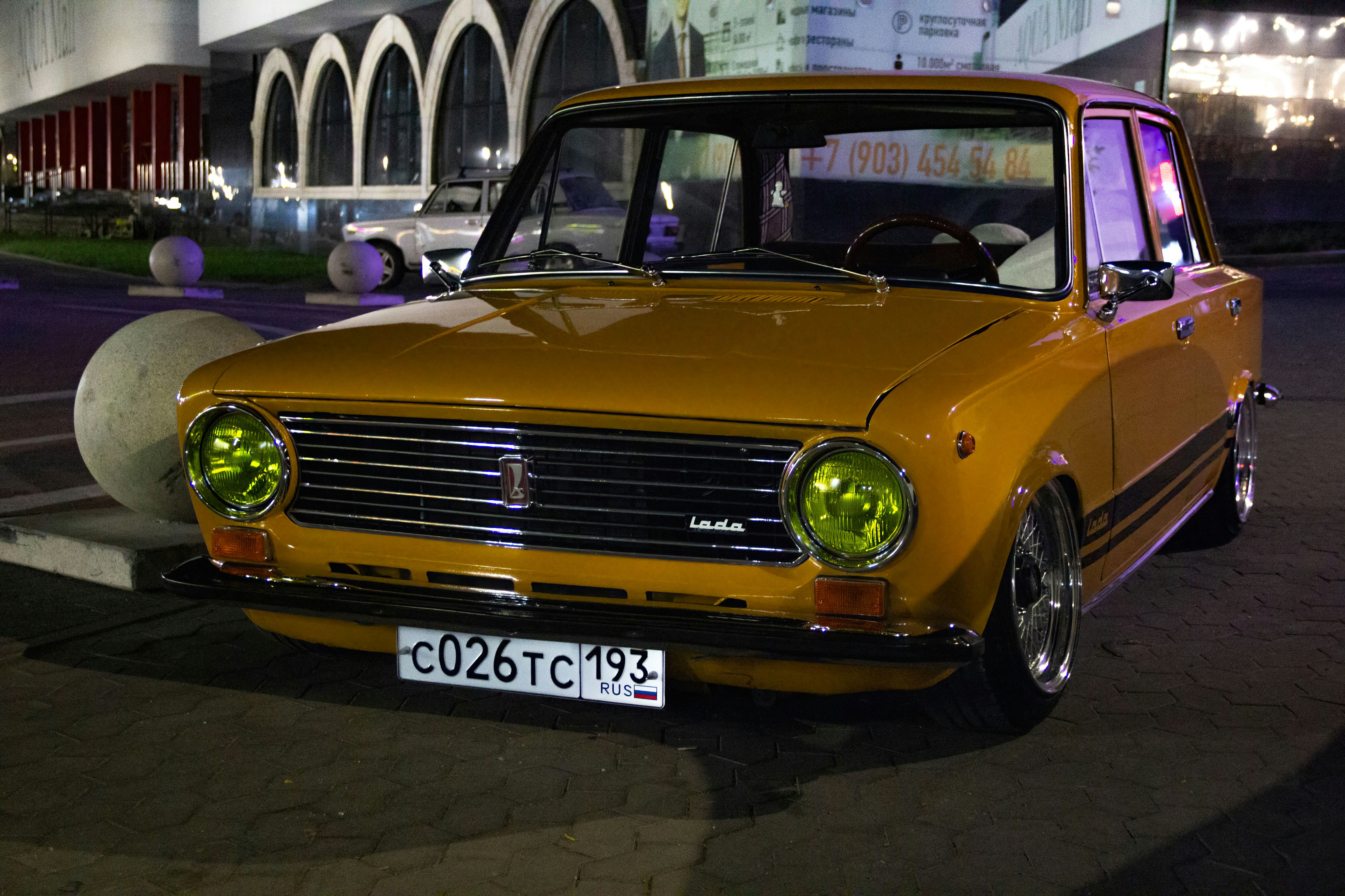 Um carro amarelo estacionado em frente a um prédio