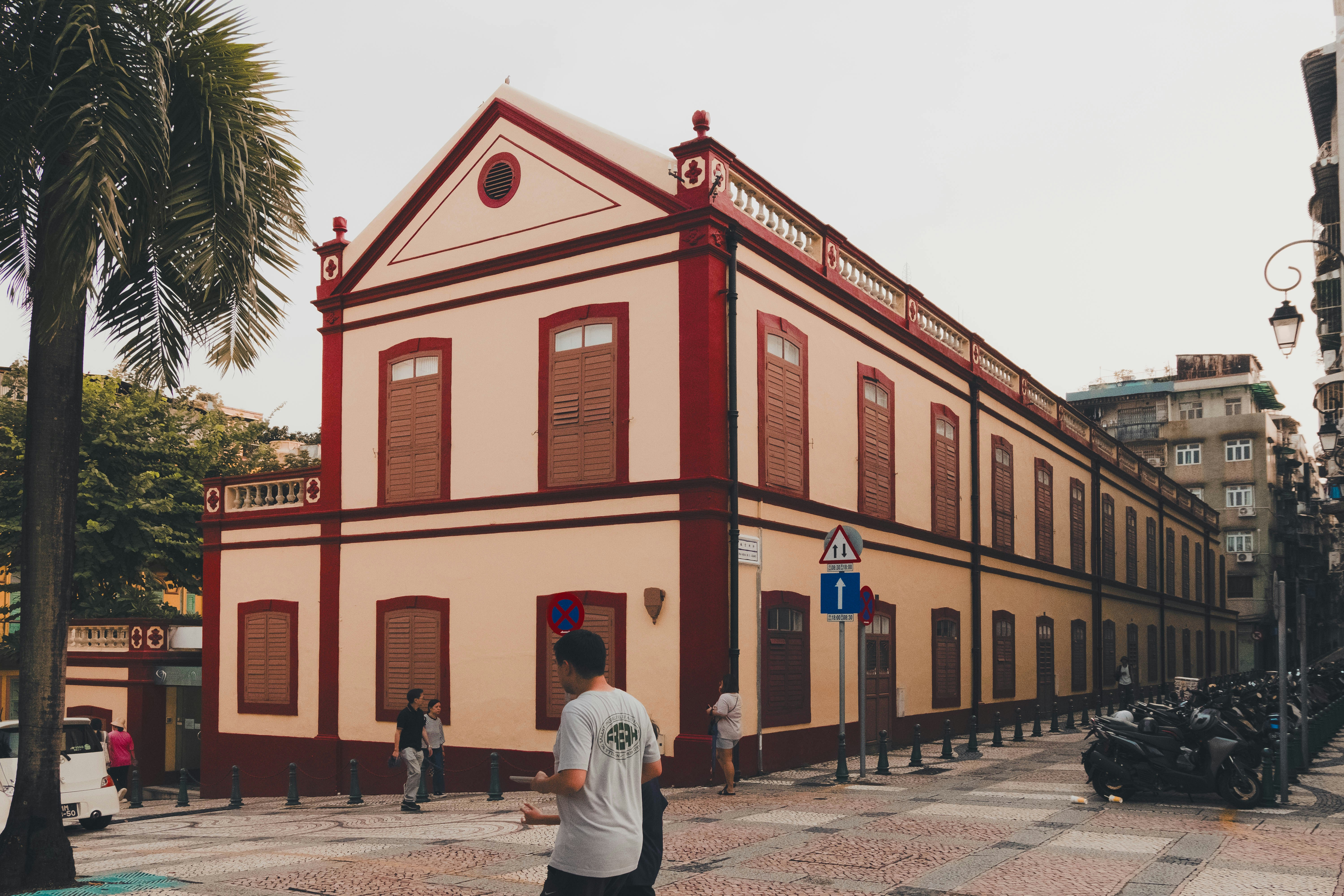 A man standing in front of a red and white building