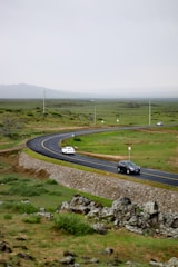 Two cars are driving down a winding road