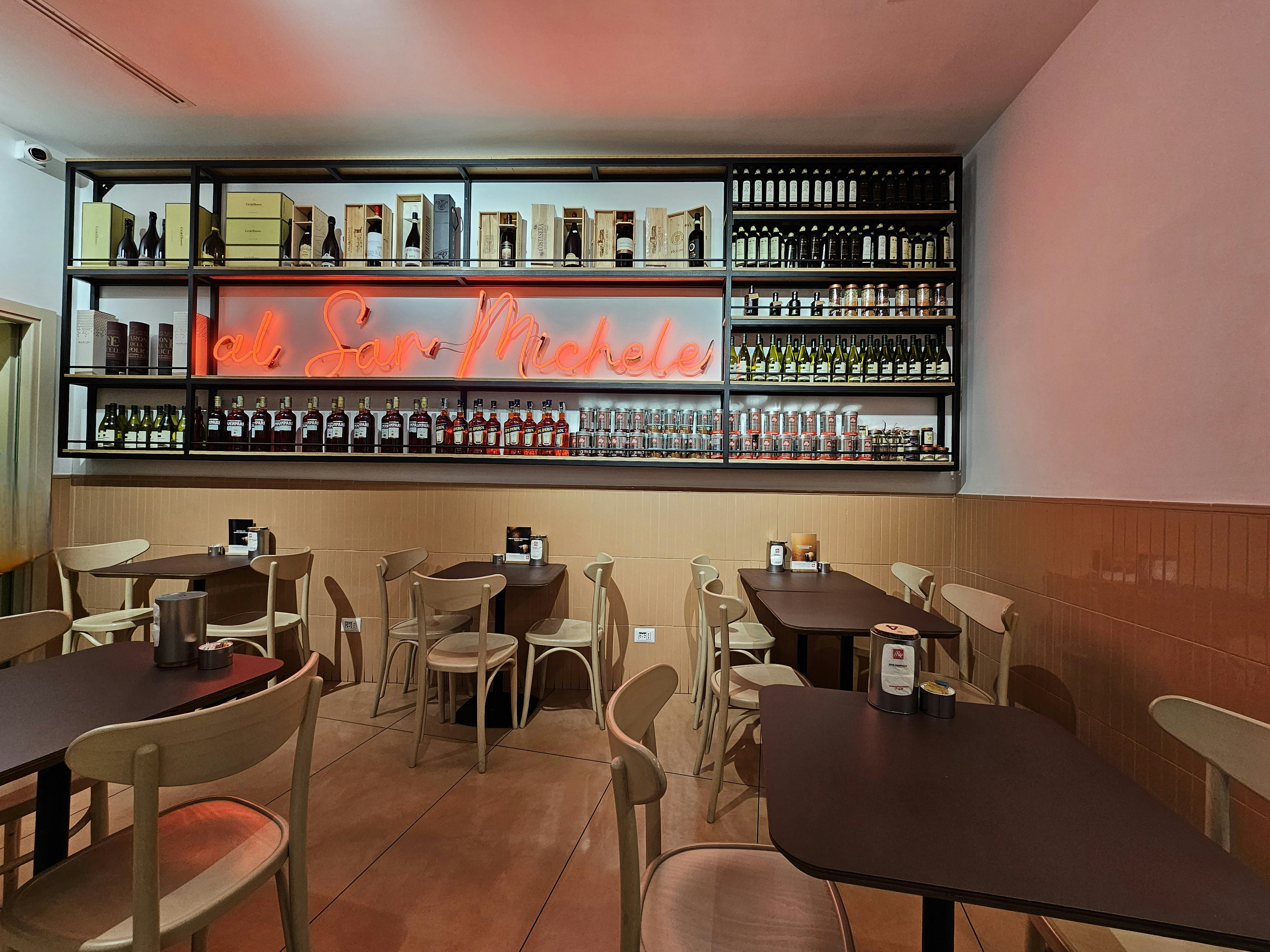 Interior de restaurante moderno con mesas y sillas de madera oscura, iluminación de ambiente cálida y paredes de ladrillo expuesto