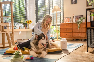 A woman sitting on the floor with two dogs