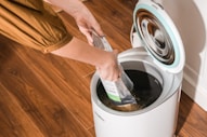 A person putting something in a trash can