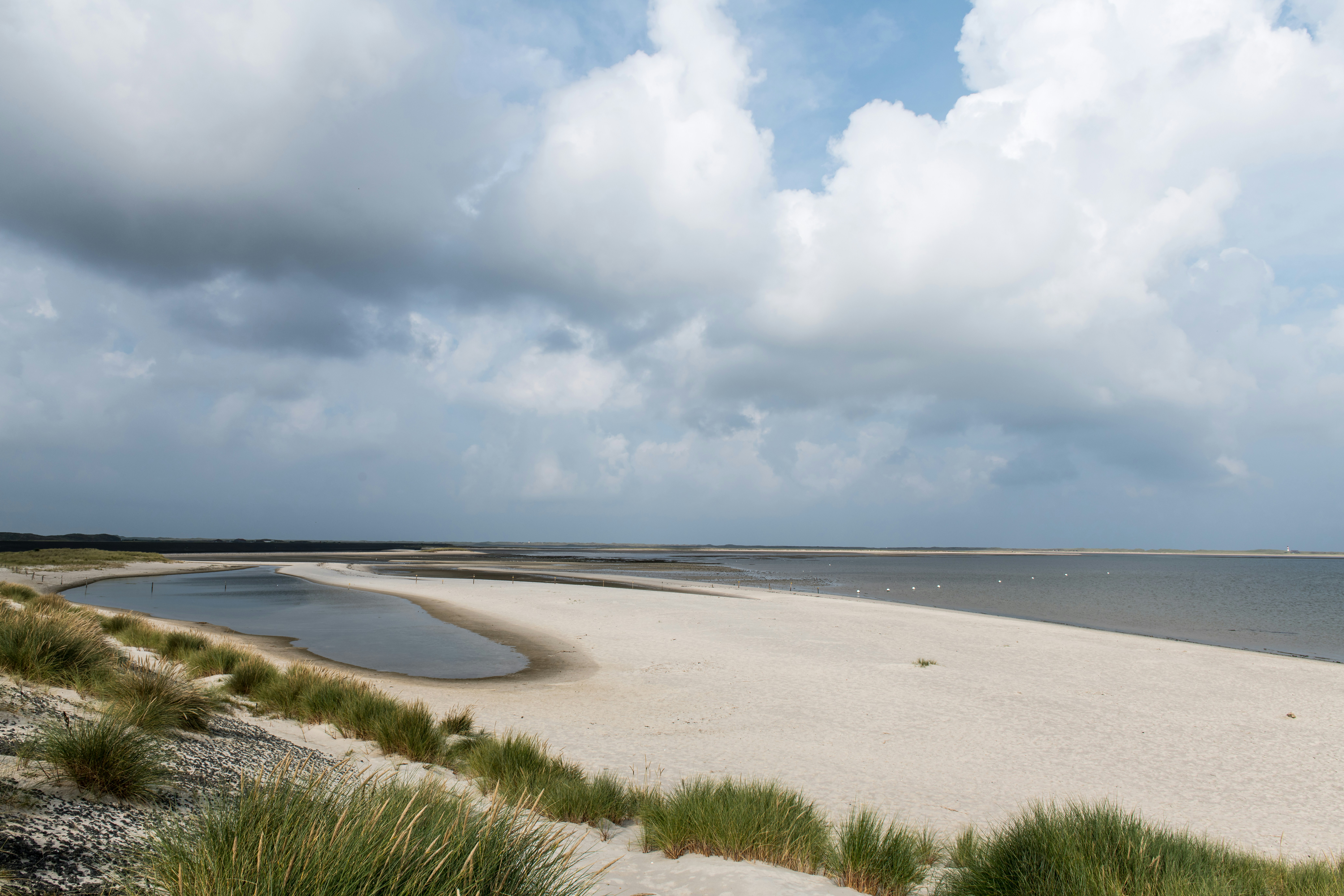 A sandy beach with a body of water in the distance