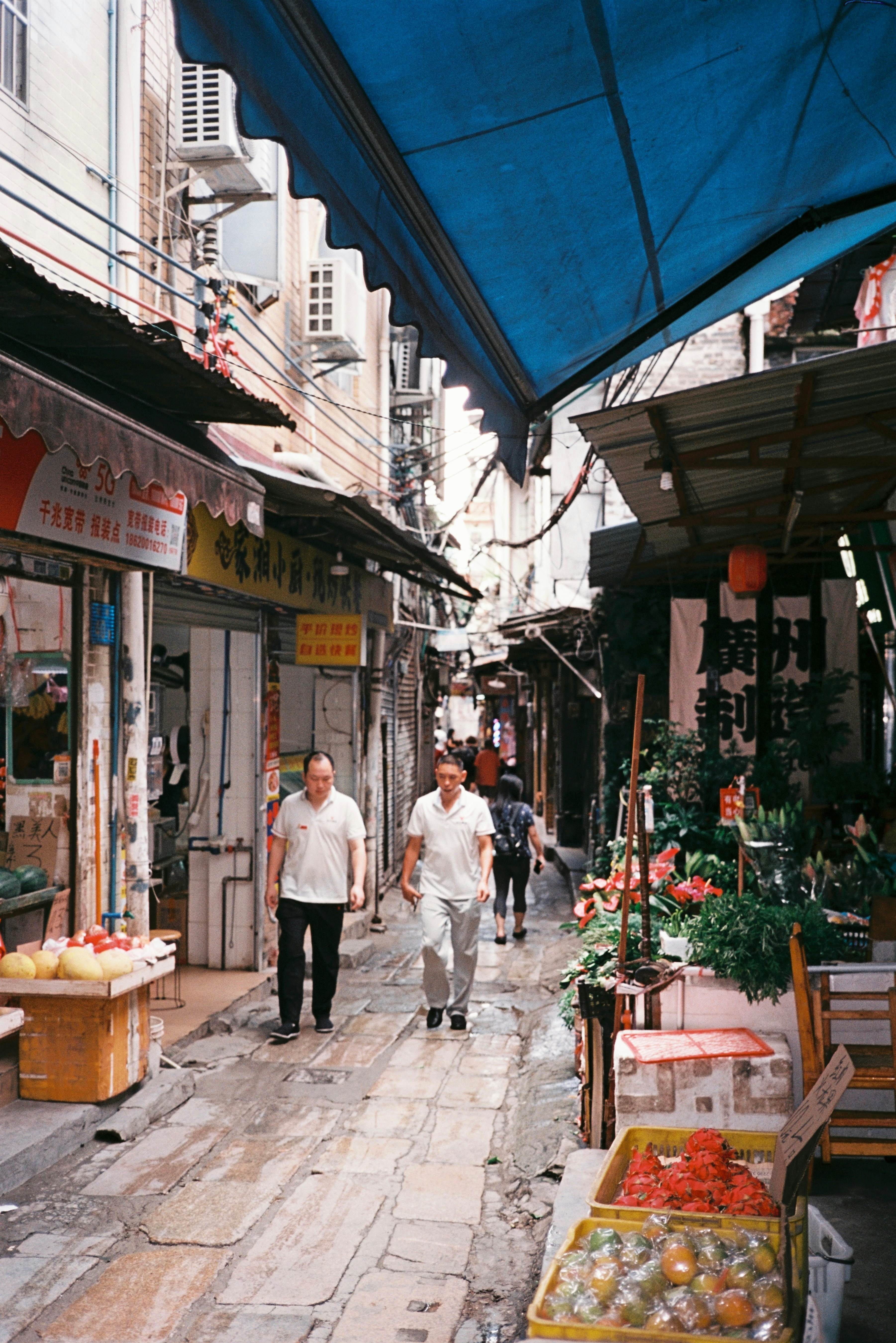 A couple of people walking down a street
