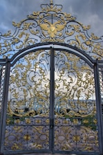 A large metal gate with gold designs on it