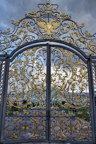 A large metal gate with gold designs on it