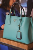 A woman sitting at a table with a blue purse