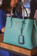 A woman sitting at a table with a blue purse