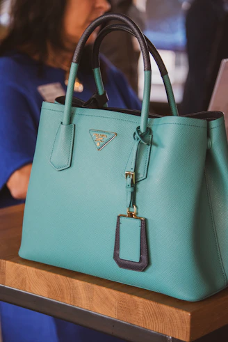 A woman sitting at a table with a blue purse