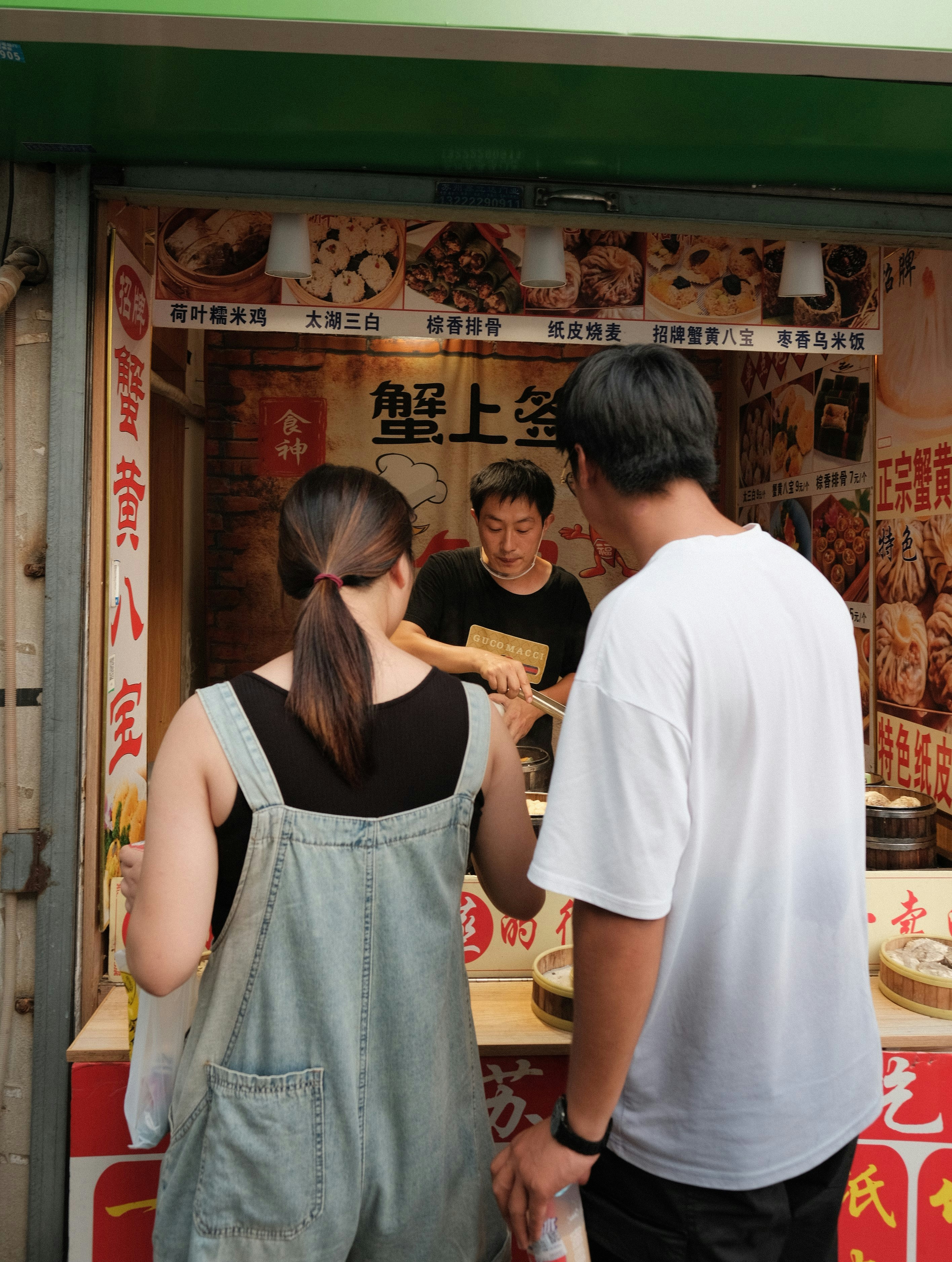 A group of people standing in front of a food stand