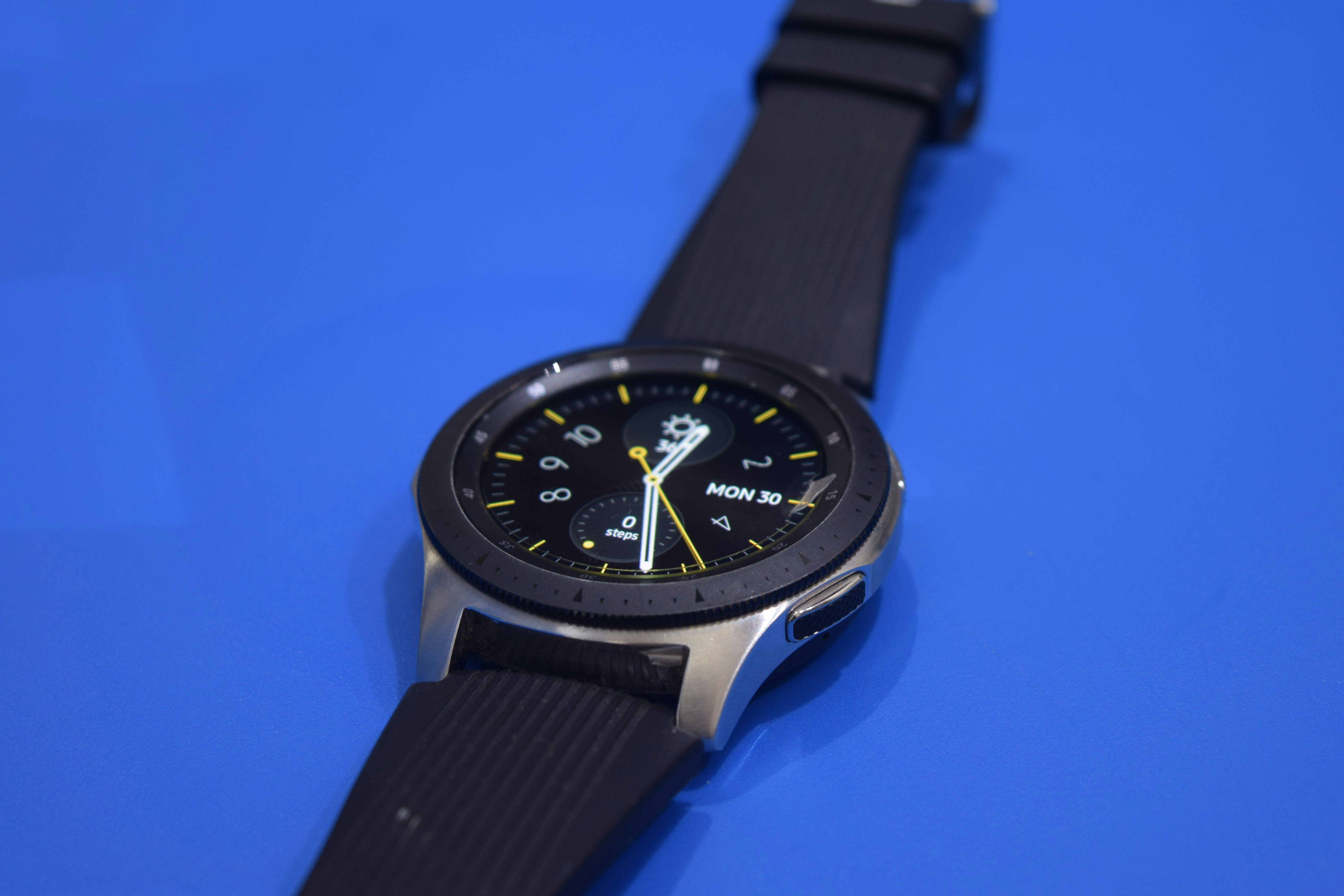 A smart watch sitting on a blue surface