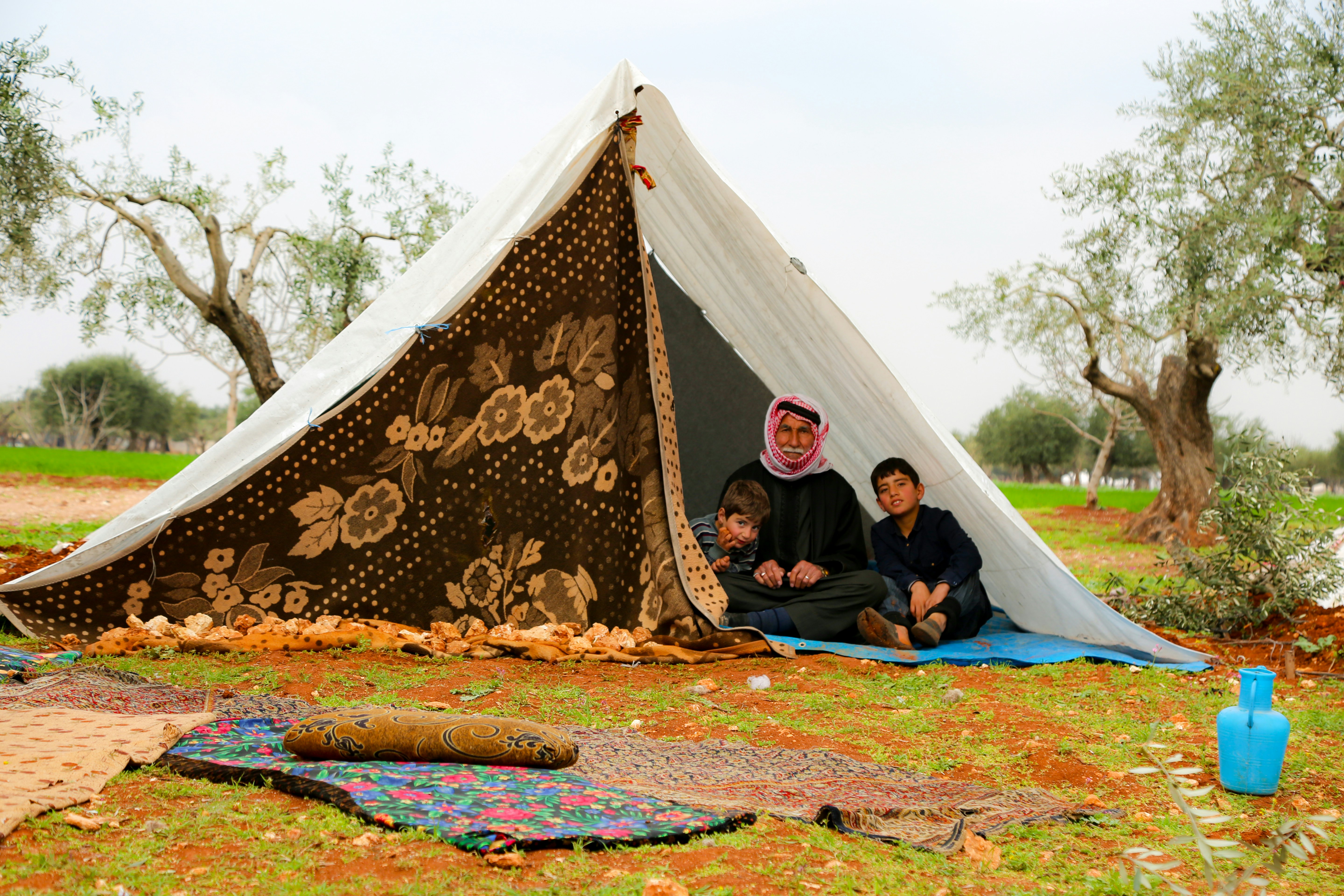 Displaced families huddle together in a makeshift tent camp amidst the rubble in Gaza - Gaza food insecurity