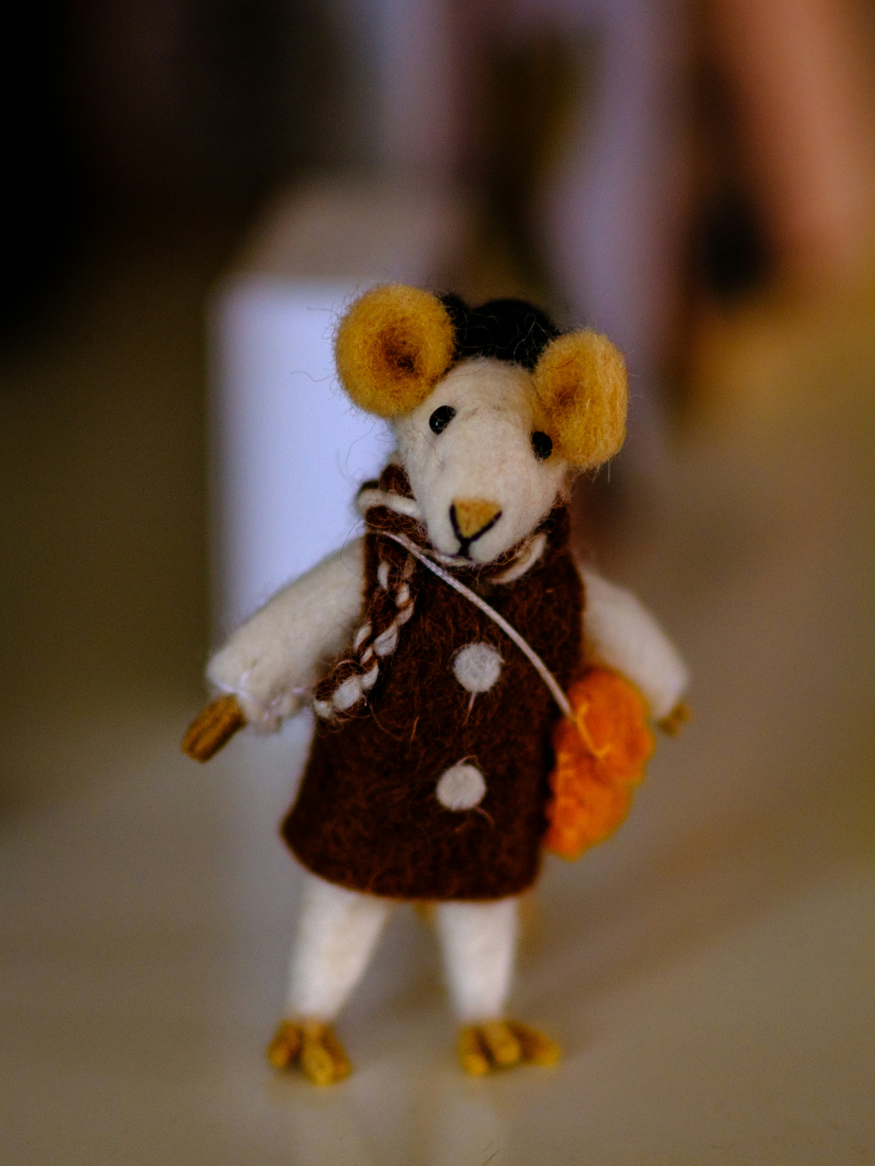 A small toy mouse wearing a brown outfit