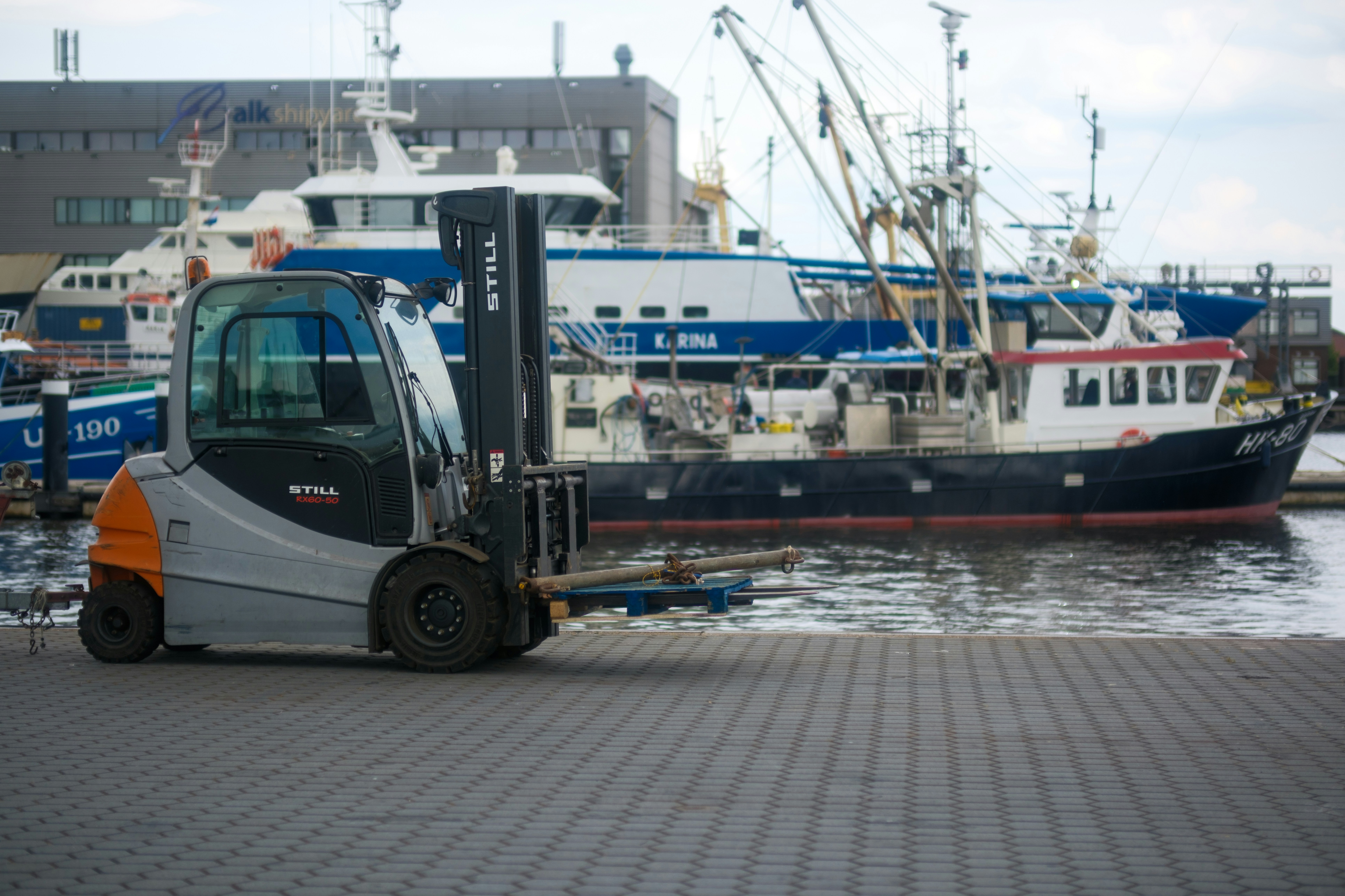A forklift with a boat in the background