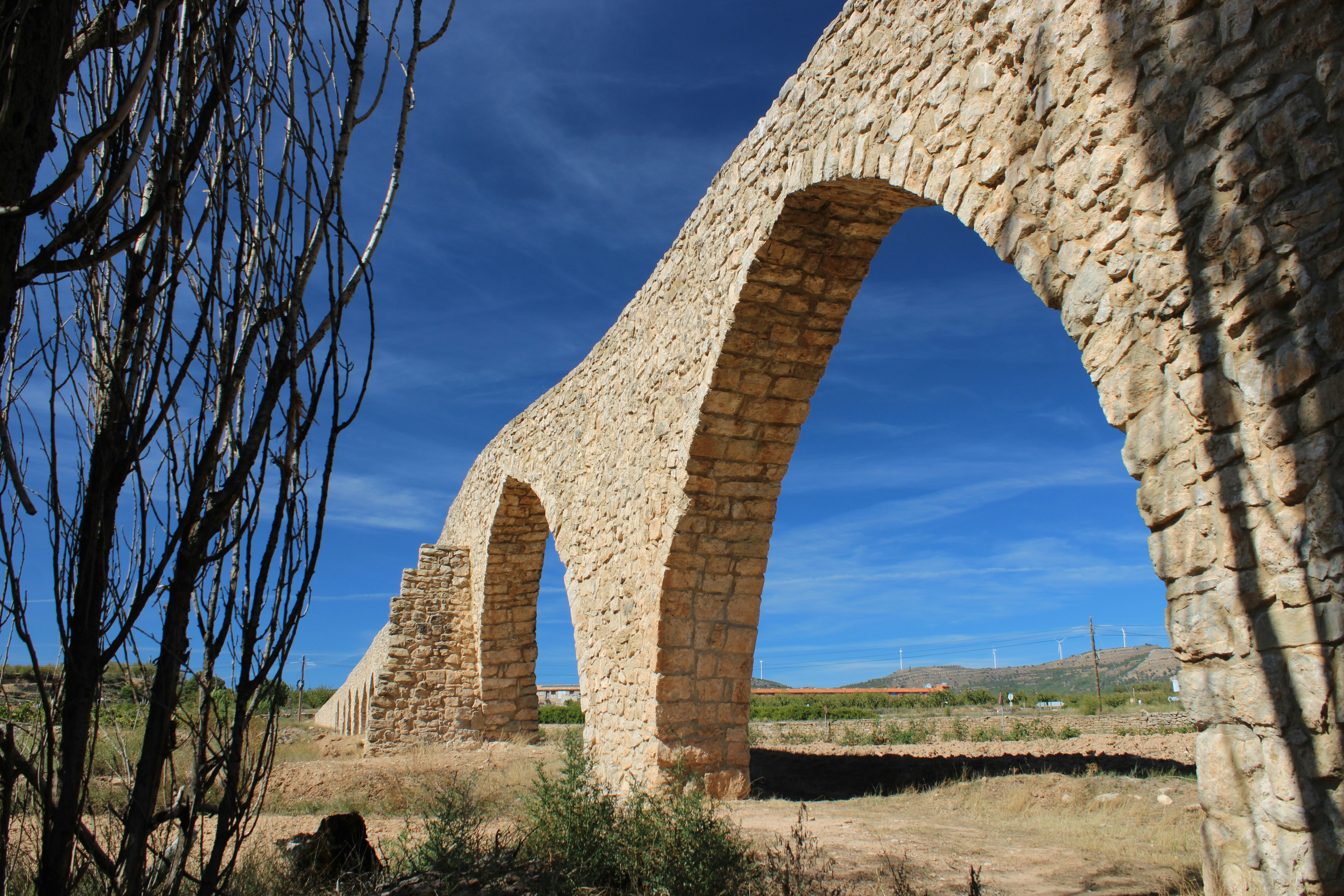 A stone arch in the middle of a field