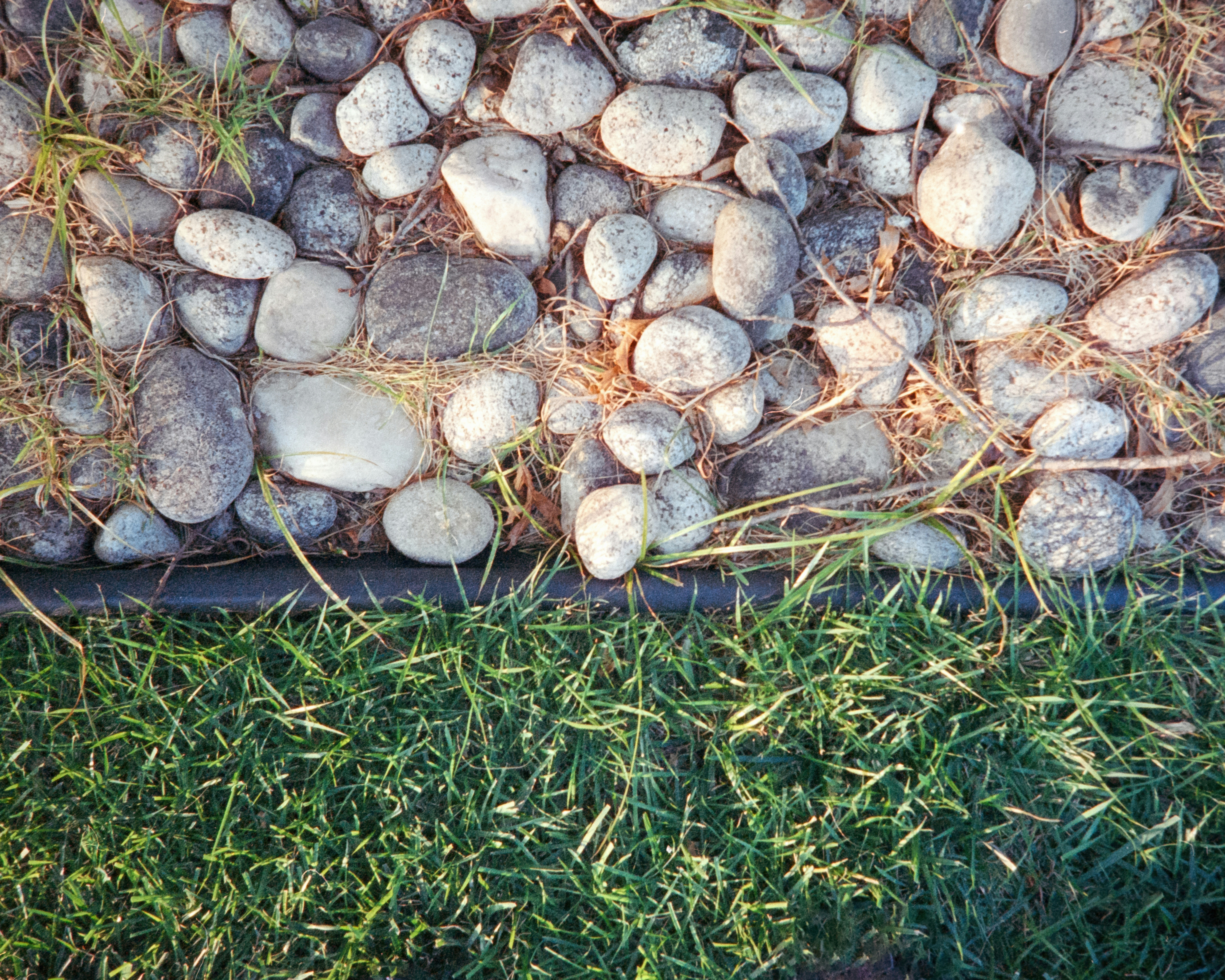 A pile of rocks sitting on top of a lush green field