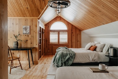 A bedroom with two beds and a desk