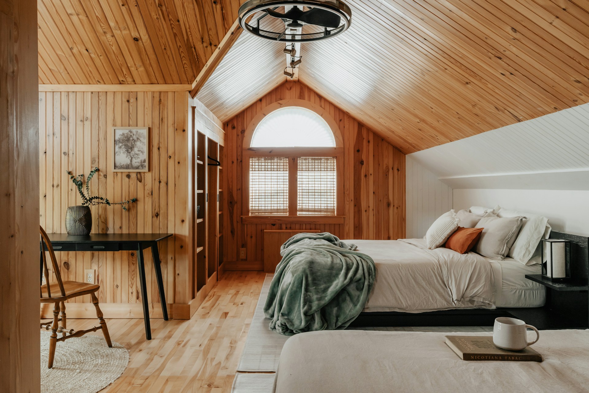A bedroom with two beds and a desk