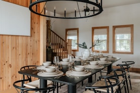 A dining room with a table and chairs and a chandelier