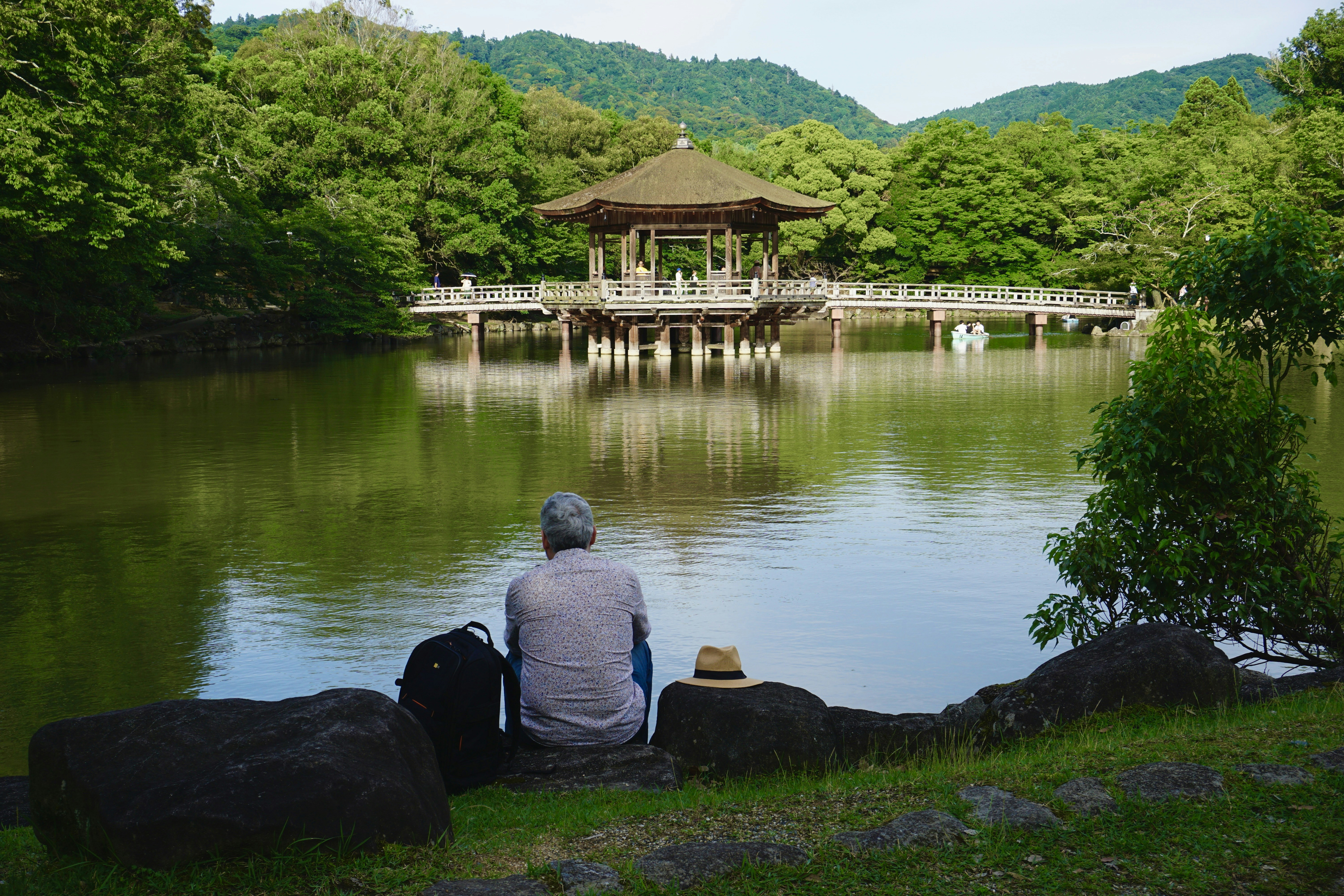 A man sitting on a rock looking at a lake