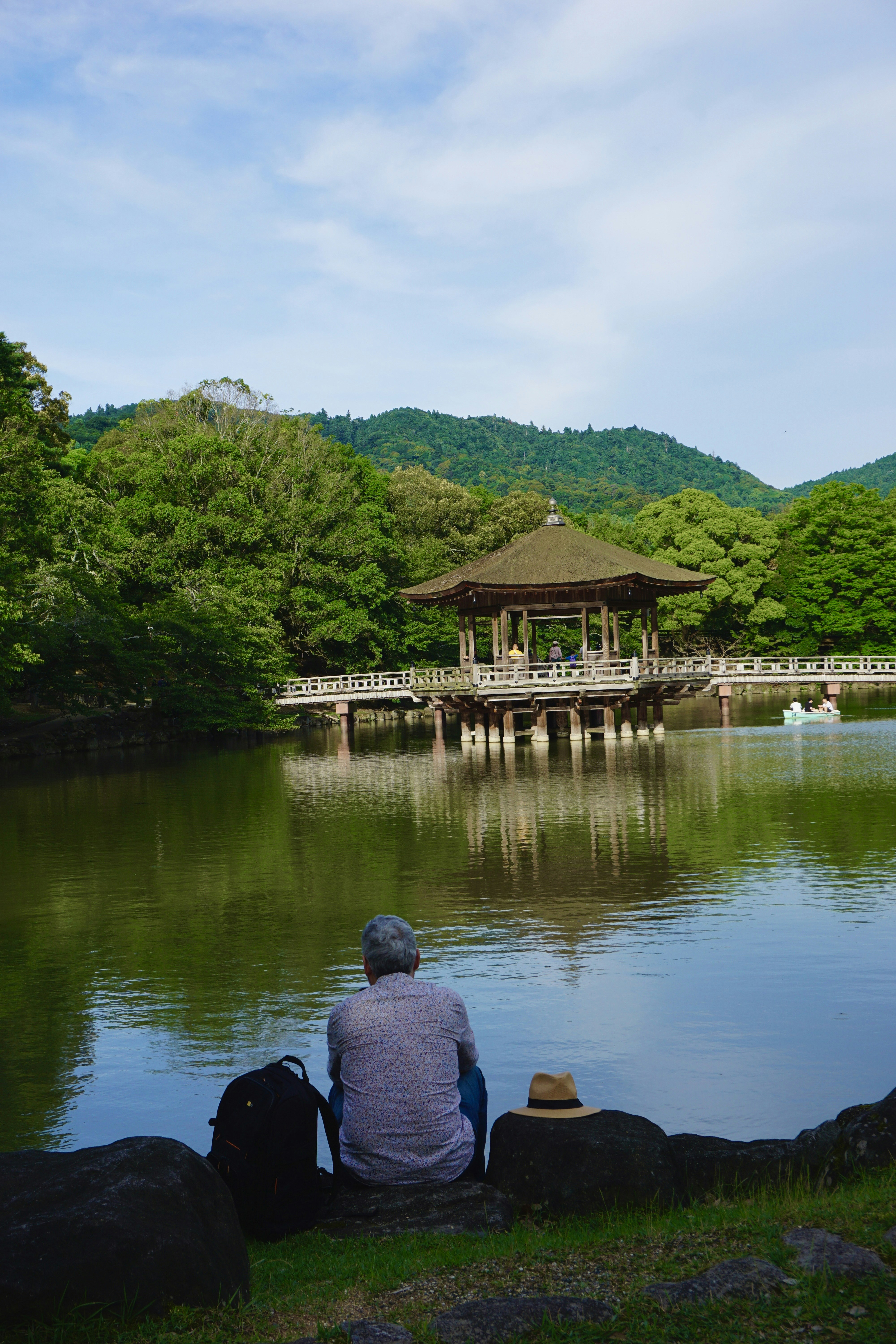 A man sitting on the edge of a lake