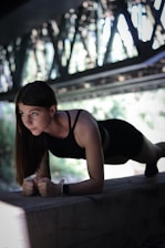 A woman in a black top is leaning on a ledge