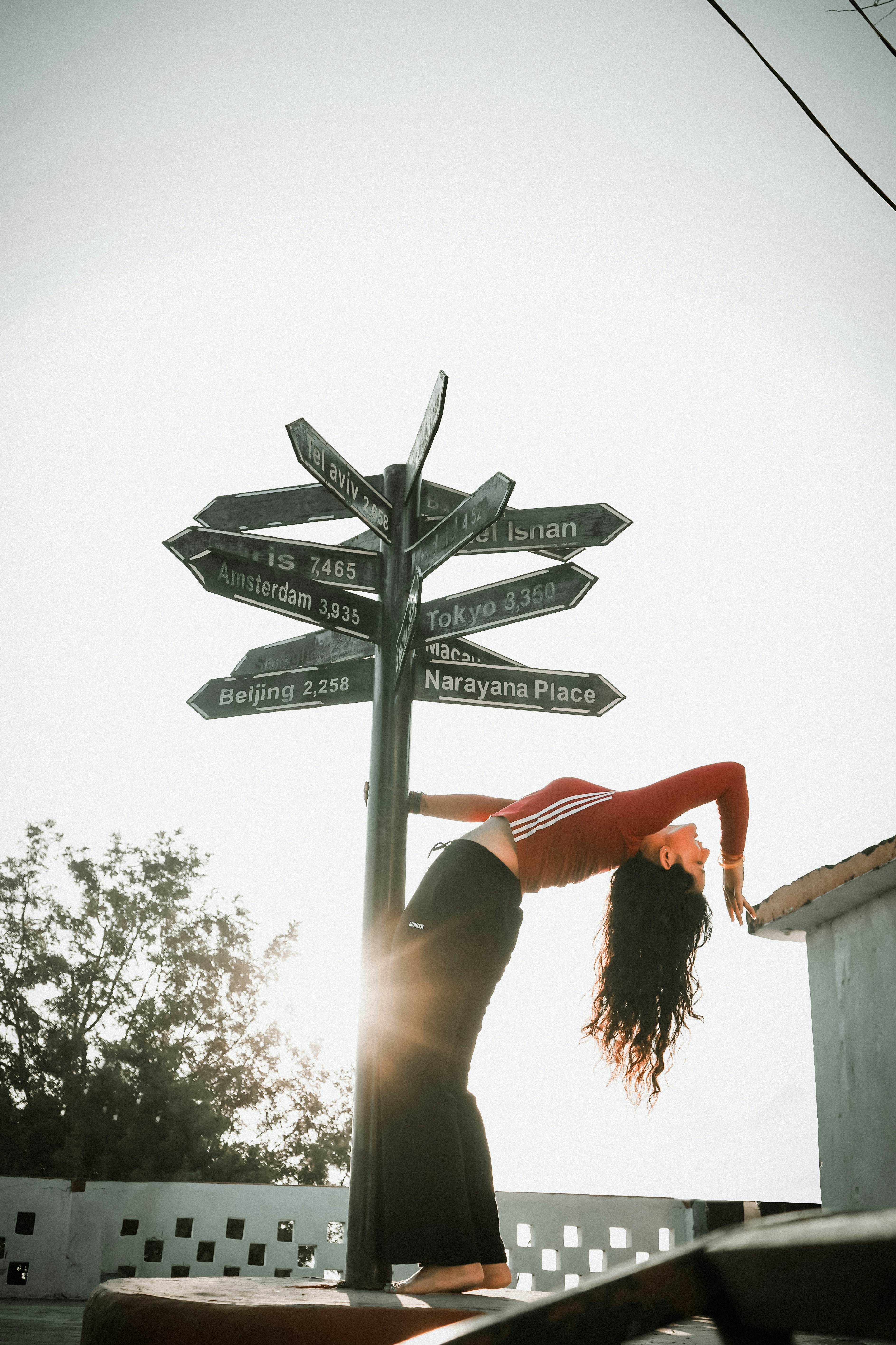 A woman doing a handstand in front of a street sign