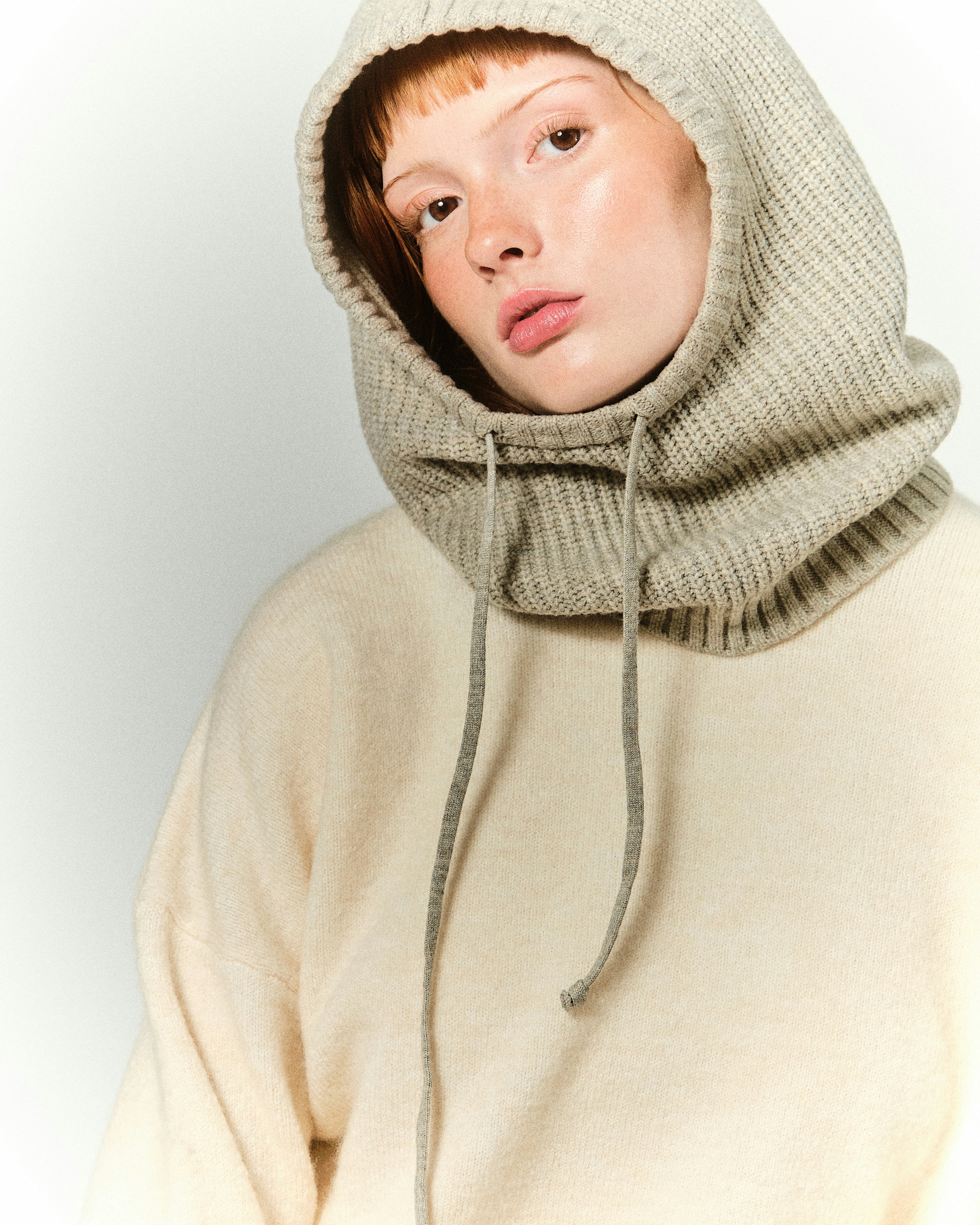 A young woman wearing a hoodie and looking at the camera