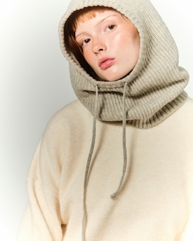 A young woman wearing a hoodie and looking at the camera