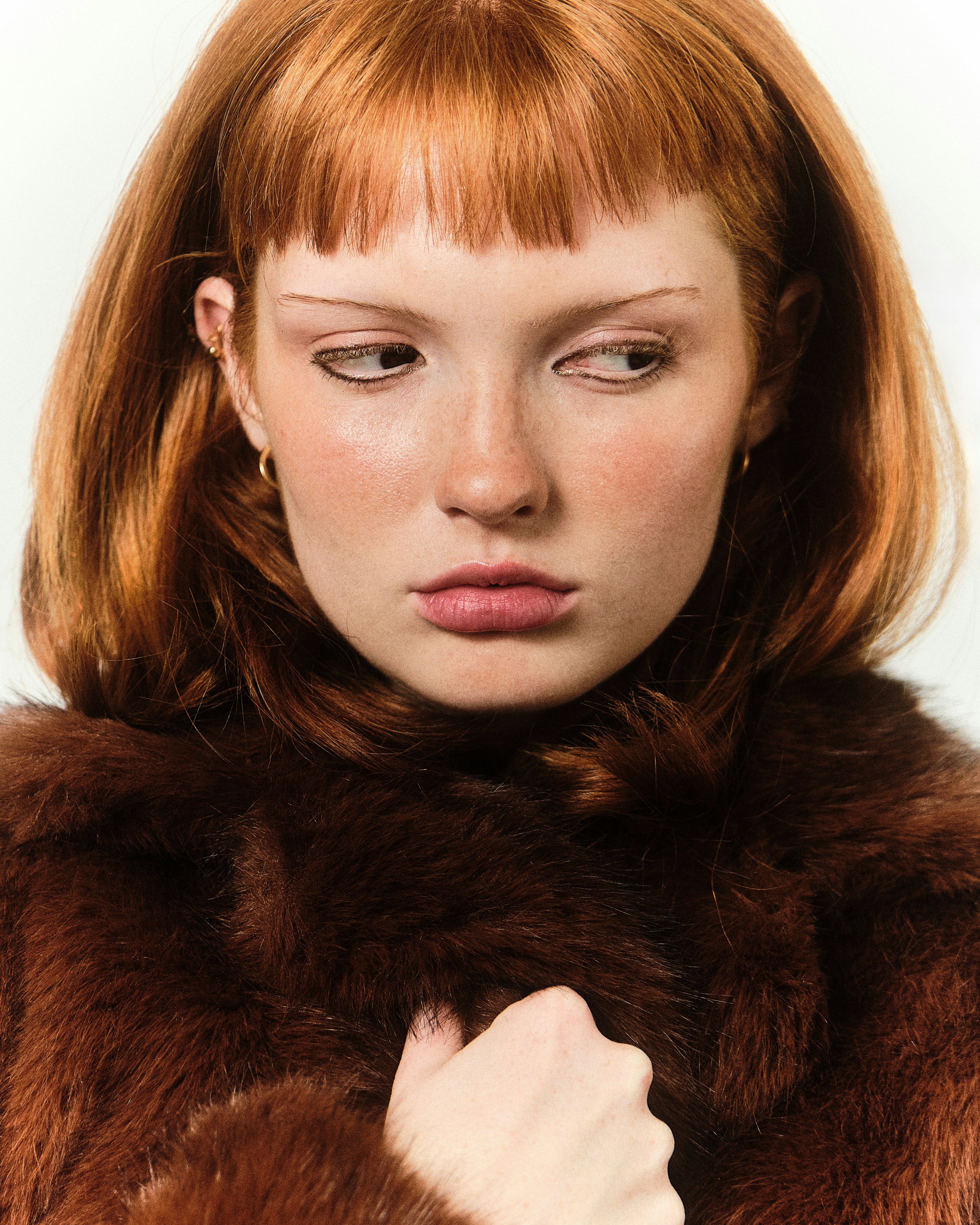 A woman with red hair wearing a fur coat