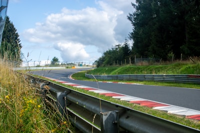 A curved road with grass growing on the side of it