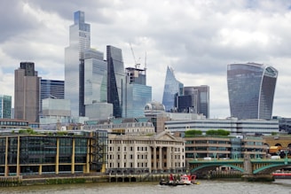 A boat traveling down a river next to tall buildings