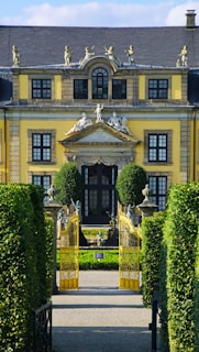 A large yellow building with many windows and a gate