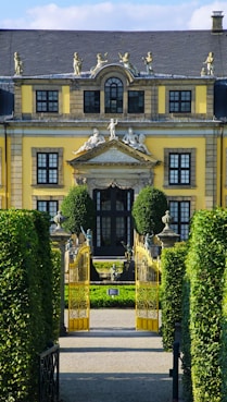 A large yellow building with many windows and a gate