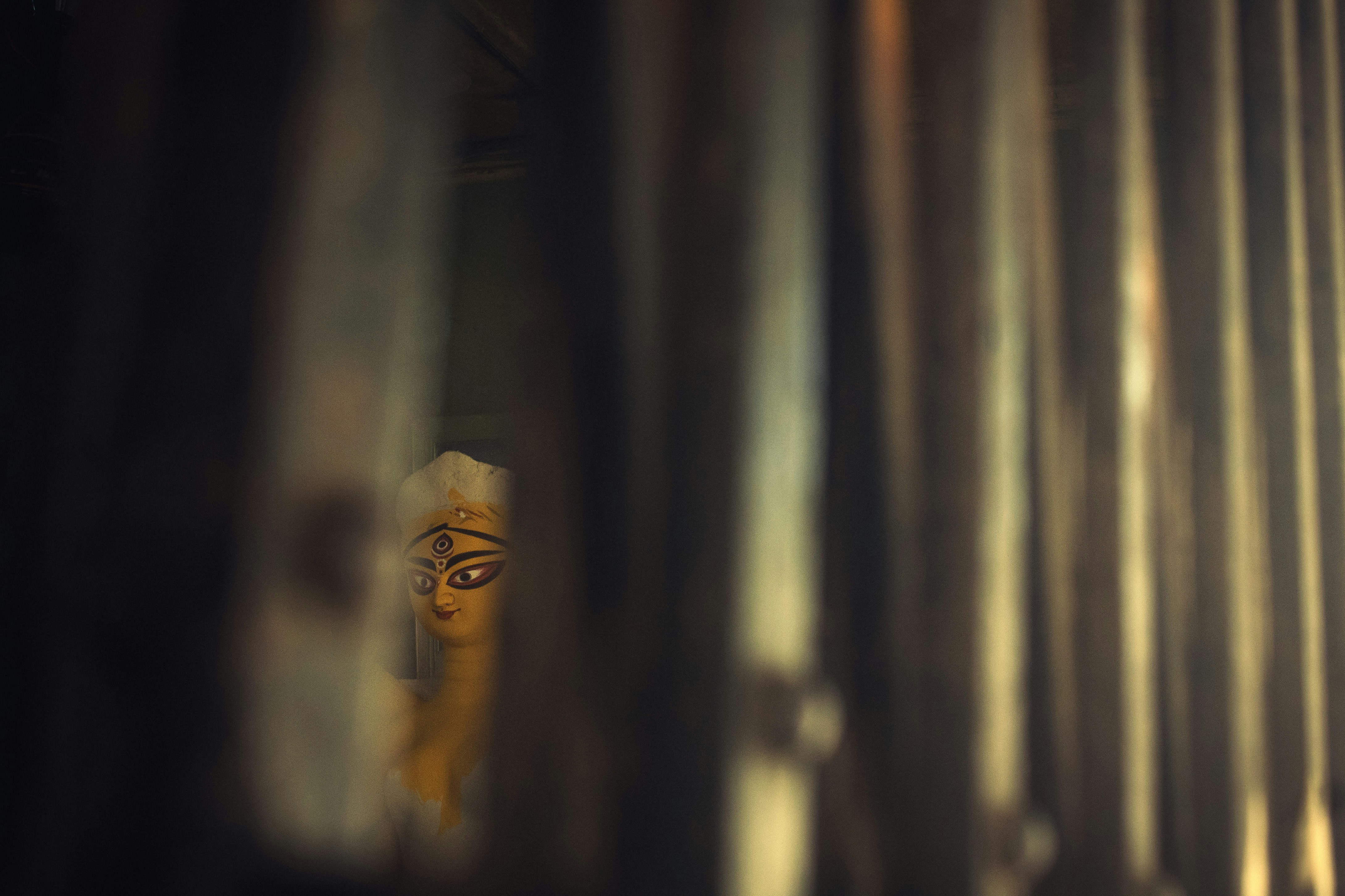 A blurry photo of a man's face through a row of metal pipes